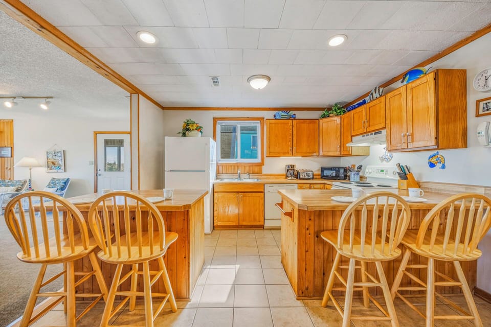 Your spacious kitchen welcomes you with warm wood cabinets, granite counters, and a breakfast bar perfect for morning coffee.