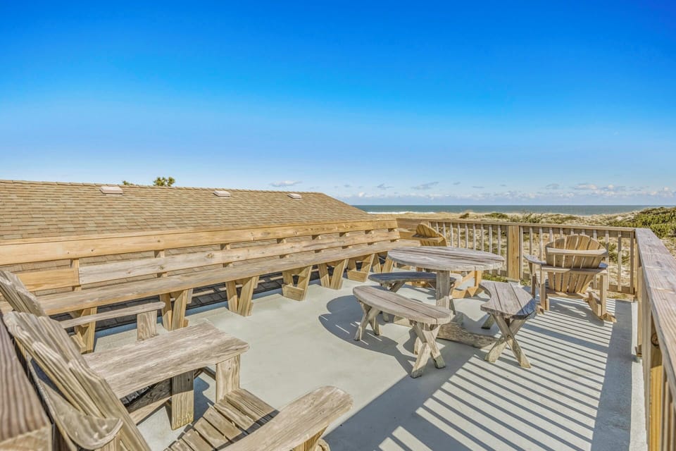 Elevated deck offers panoramic ocean views with picnic tables and benches for outdoor dining and relaxation.