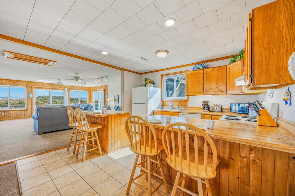 Gather around your spacious kitchen island with breakfast bar seating while enjoying panoramic views through wraparound windows.
