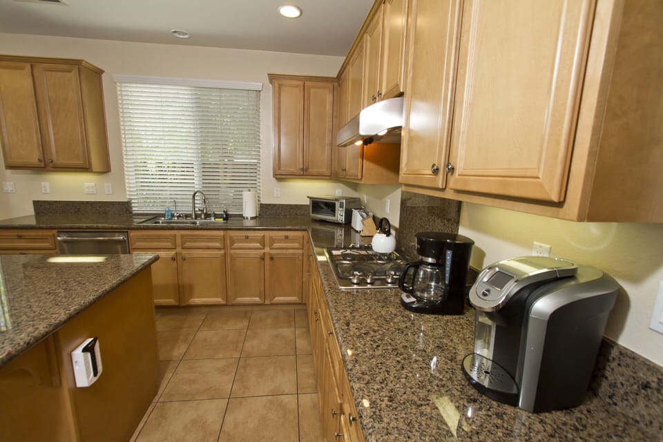 Stainless steel appliances include refrigerator, stove, oven, K & filter coffee 