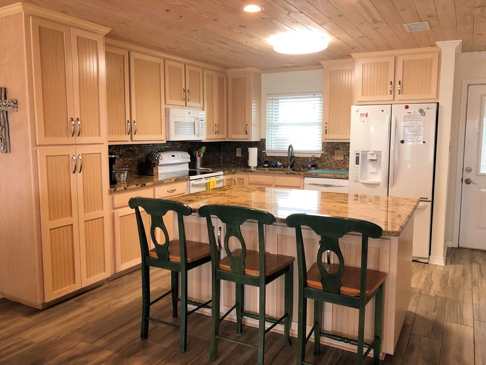 Your spacious kitchen features warm wood cabinets, granite countertops, and a breakfast bar where you can start each morning with coffee.
