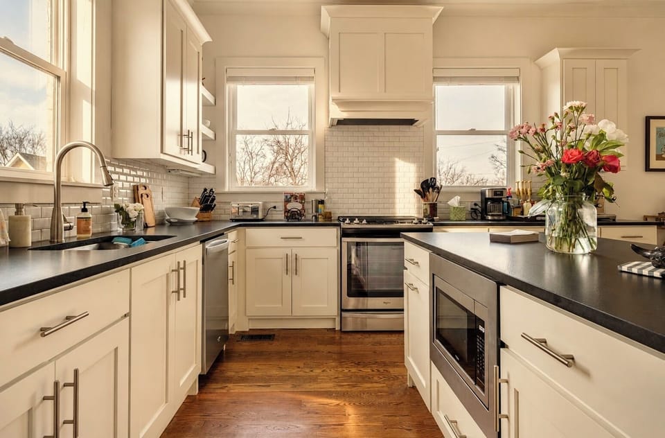 Bright designer kitchen with island, subway tile, and sunny windows
