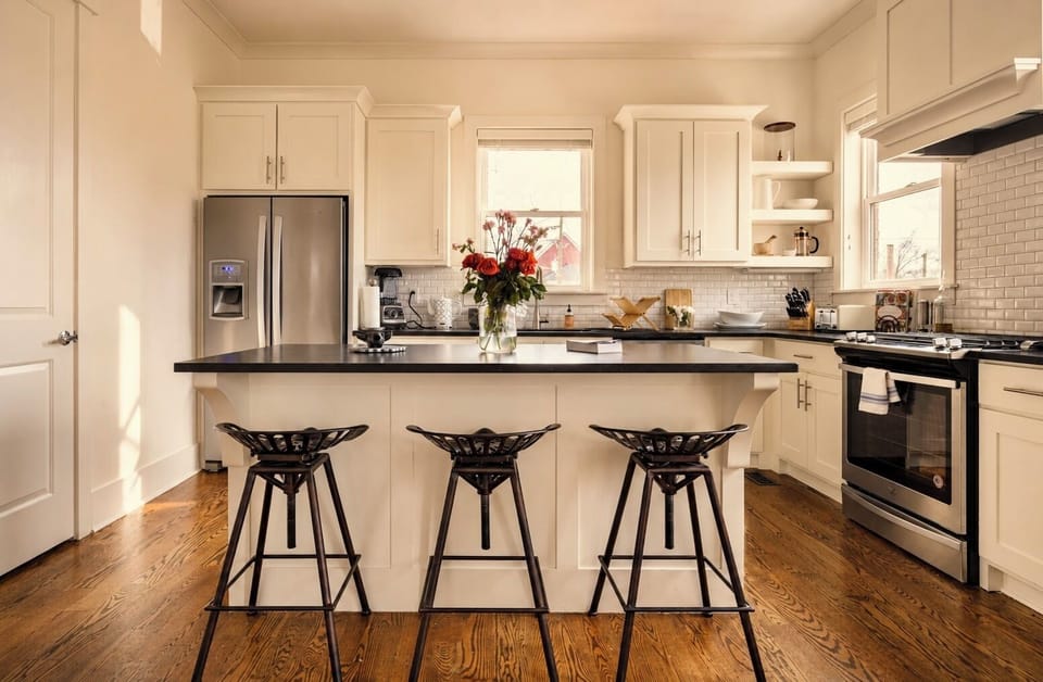 Bright designer kitchen with island seating and stainless steel appliances
