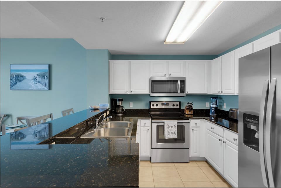 You'll love cooking in this bright kitchen with granite counters, stainless appliances, and coastal blue walls that create a refreshing beachside vibe.