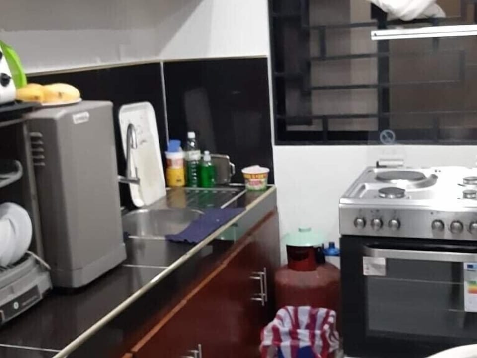 Dirty kitchen with 4 burners gas  stove and electric oven 
