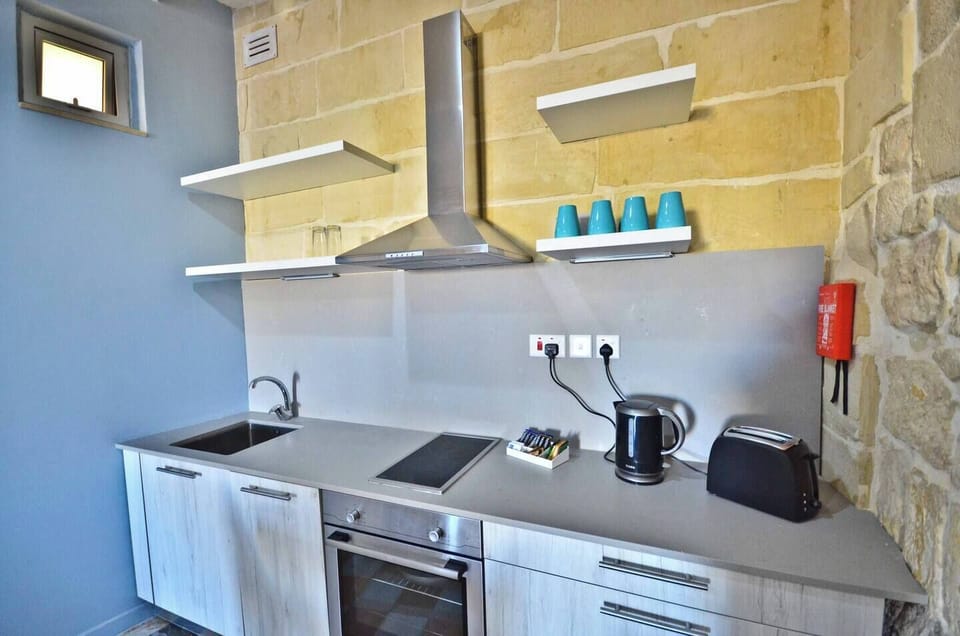 Kitchen area equipped with a refrigerator, electric cooker, oven, kettle, toaster, coffee machine, dishwasher and microwave.
