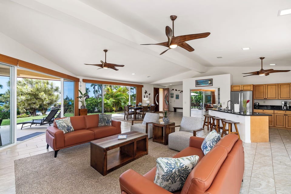 Sink into plush leather seating while tropical breezes and warm sunlight flow through your open-plan living space, where ceiling fans gently cool your island escape.