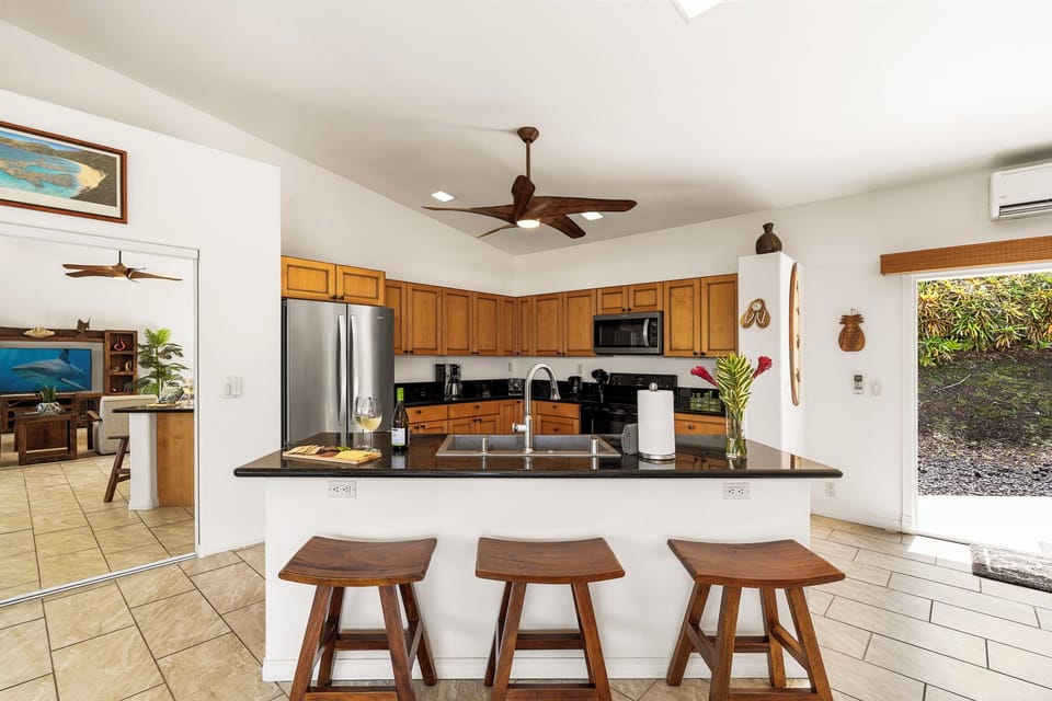 Step into your open-concept kitchen with a spacious island, dark granite counters, and modern appliances—perfect for prepping meals while staying connected to your group.