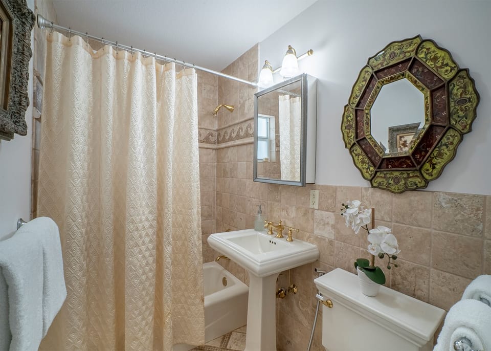 A full bathroom in hall way w/ all necessary amenities plus plush white towels. 