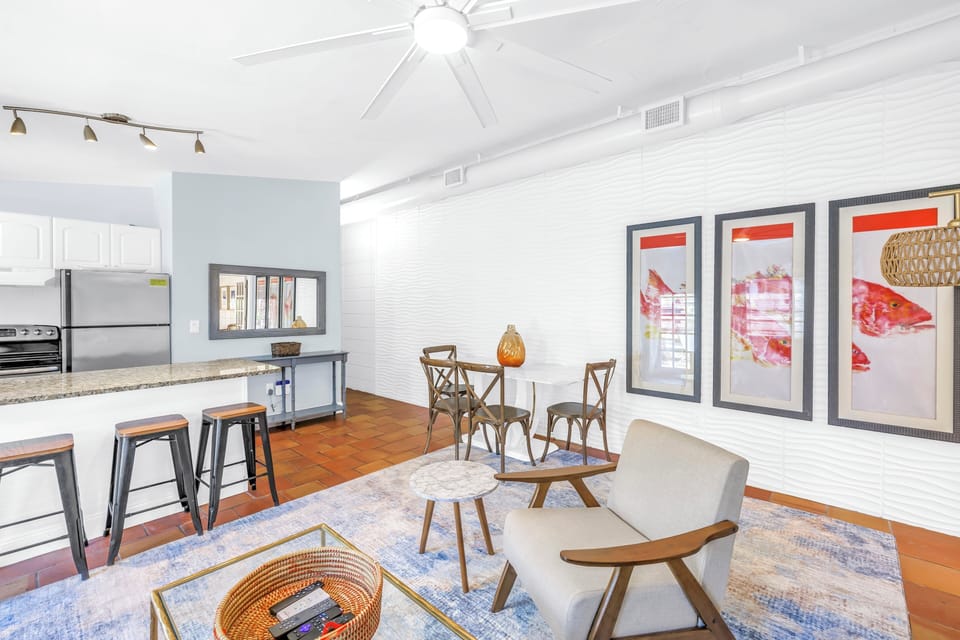 Sunny breakfast bar for three and dining area with modern paintings.