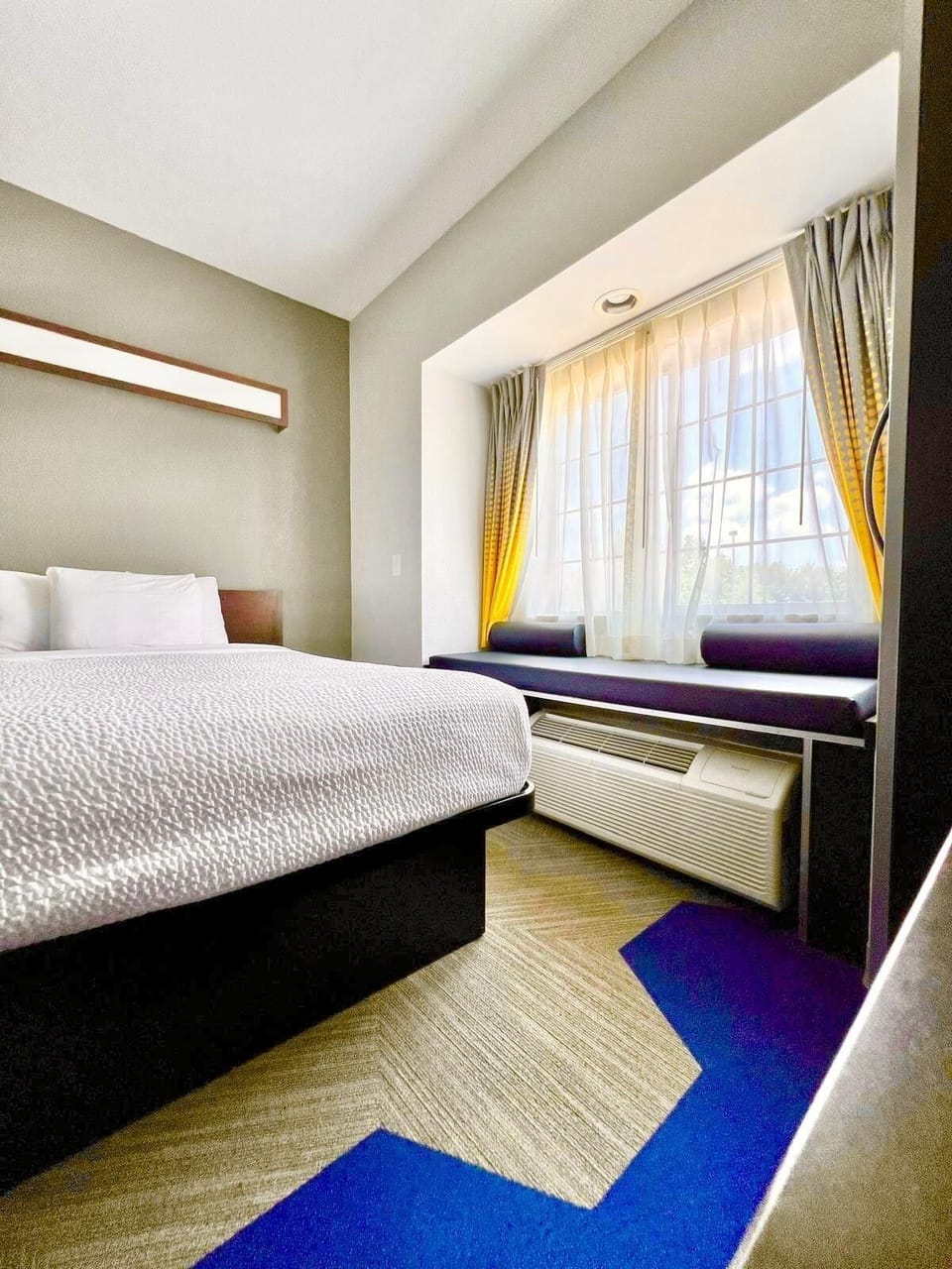 Hypo-allergenic bedding, desk, laptop workspace, blackout drapes