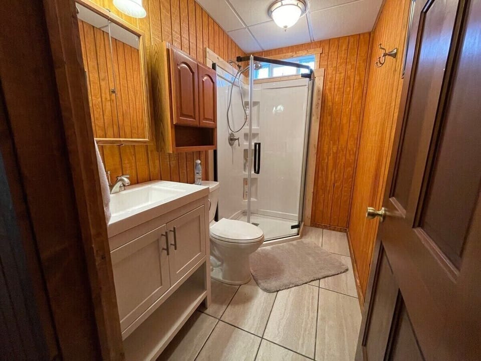 Full bath on lower level with new shower, vanity, tile floor and toilet. 