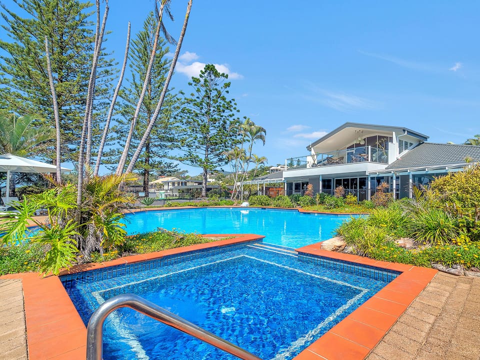 Main pool at Nautilus Beachfront boutique resort has sun loungers and spa pool