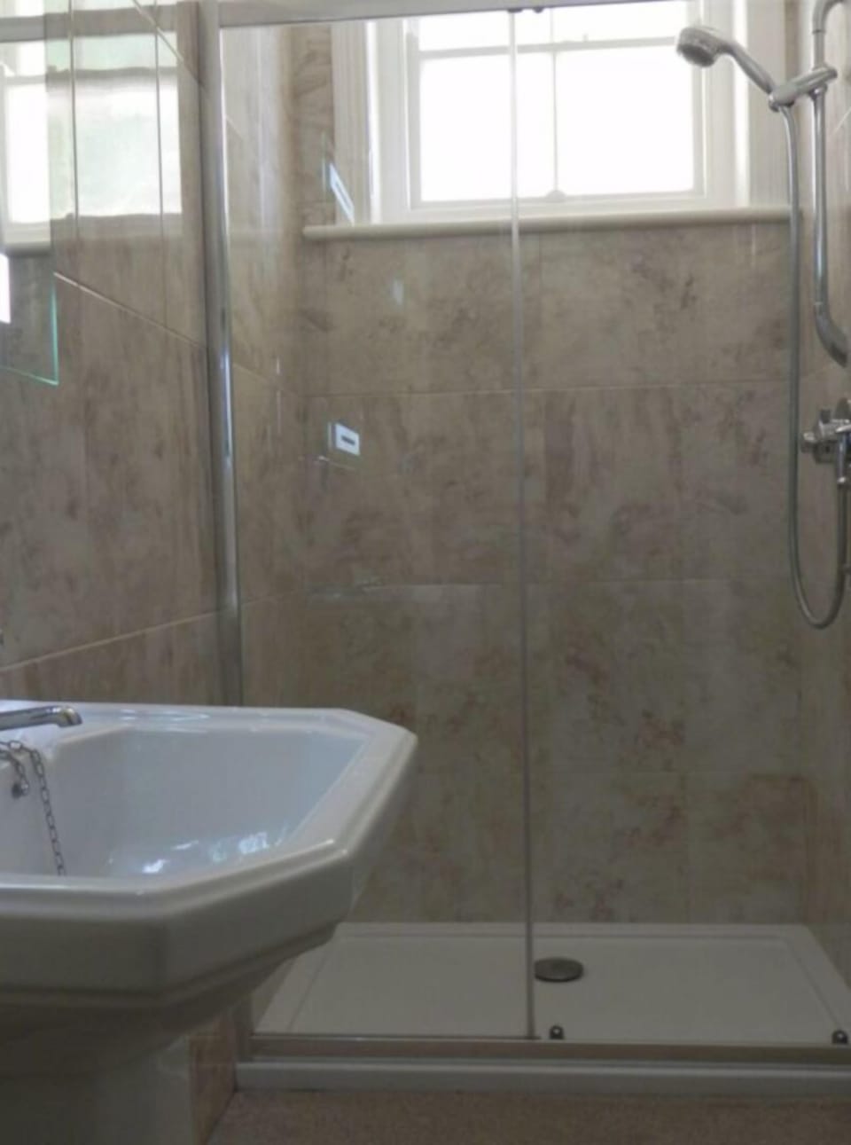 Bathroom with walk-in shower and toilet. There is another toilet off the hall