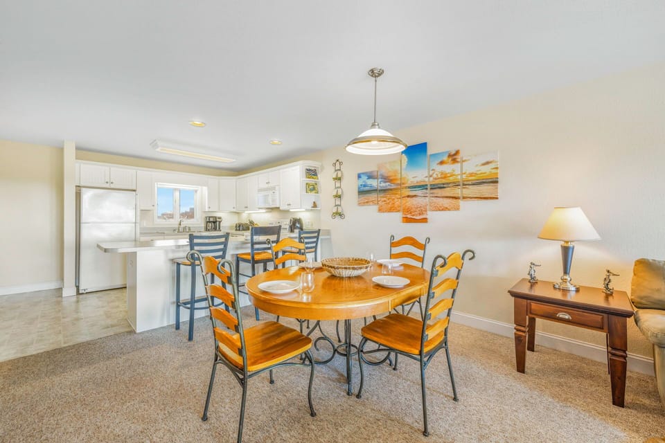 Your open-concept kitchen flows seamlessly into the dining area, where you'll gather around the warm wood table for memorable meals together.