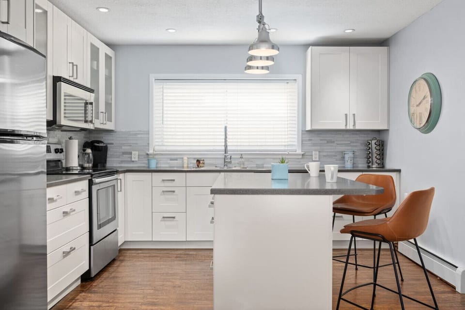 Stylish, fully equipped kitchen featuring sleek stainless steel appliances, ample counter space, and a cozy island for dining. A bright and inviting space designed for easy cooking and comfortable stays.