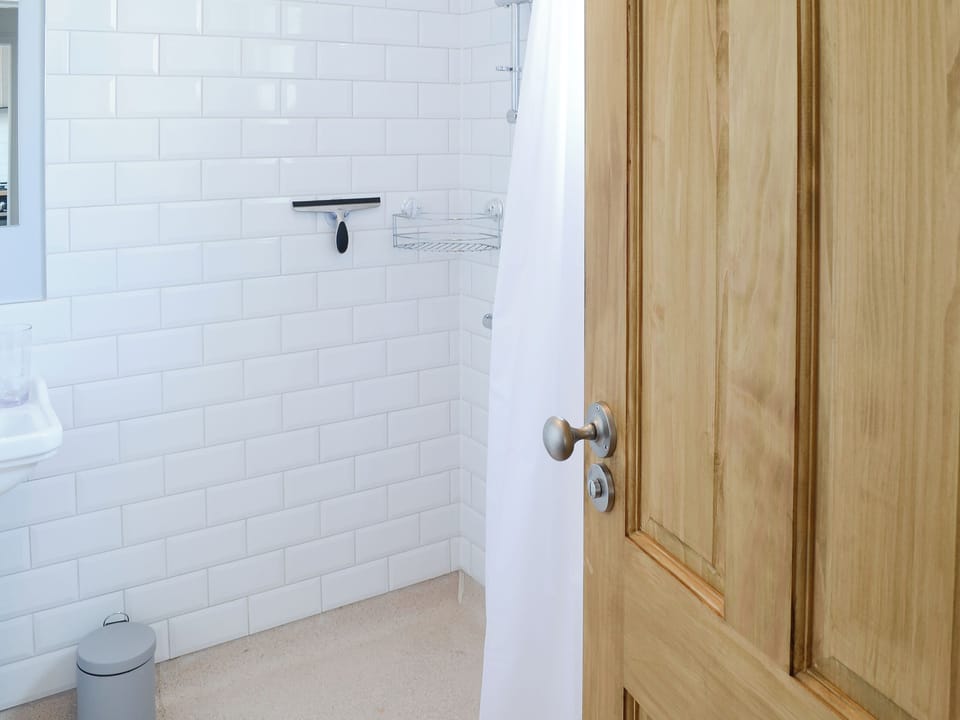 Shower room with open tiled shower area | Sea Thistle Cottage, Nairn