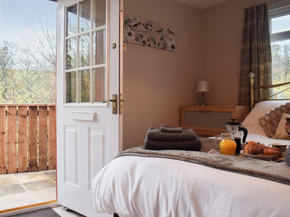Light and airy bedroom with access to the sitting out area | Pheasant Lodge, Staithes, near Whitby