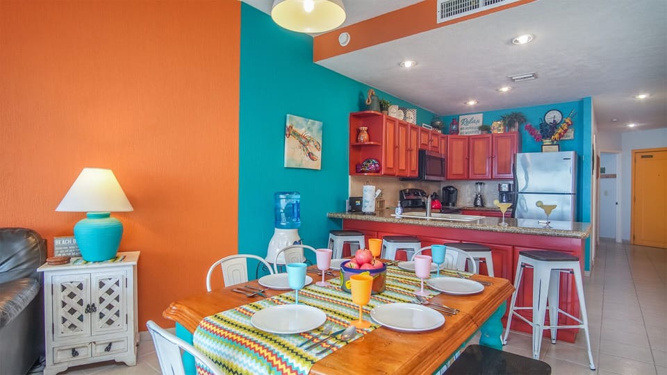 Dining table for six is augmented by additional stools set at the kitchen counter.