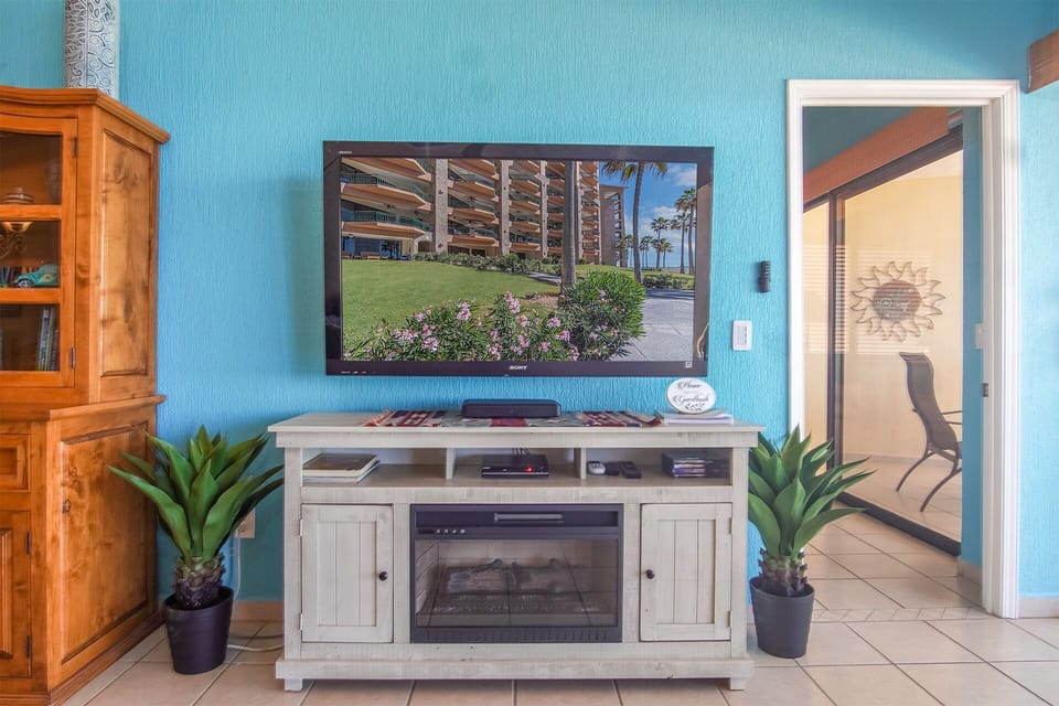 THe TV and entertainment center with fireplace below.