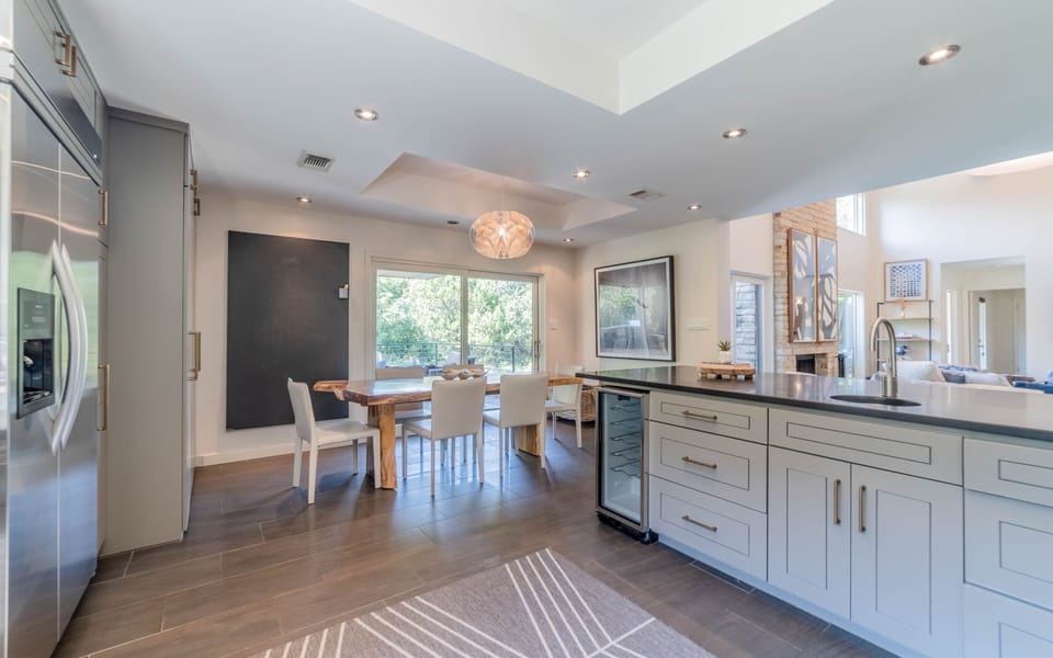 View of kitchen and dining looking out to outdoor kitchen. 