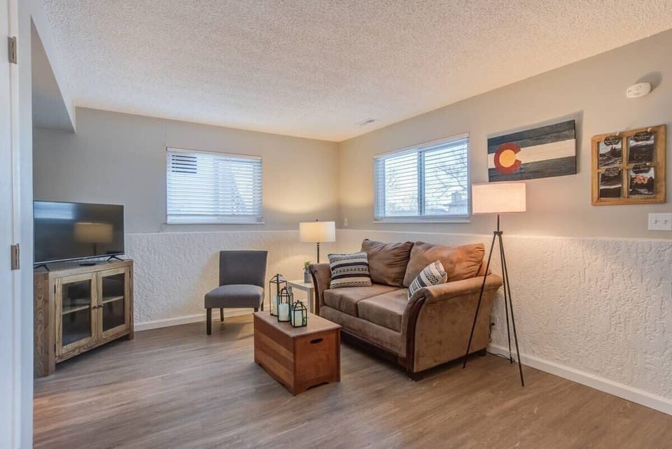 Sink into the cozy living room setup with a comfy sofa, warm floor lamp glow, and TV ready for a laid-back night in.