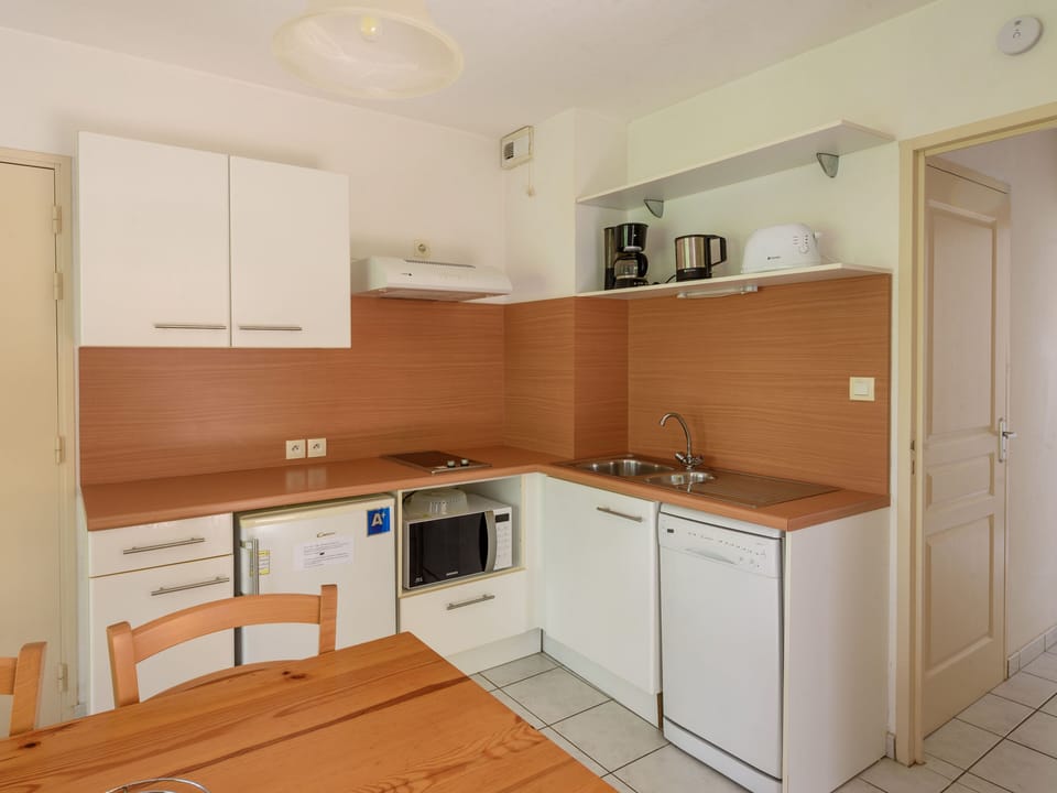 A modern kitchen with sleek cabinetry and essential appliances offers convenience for all your cooking needs.