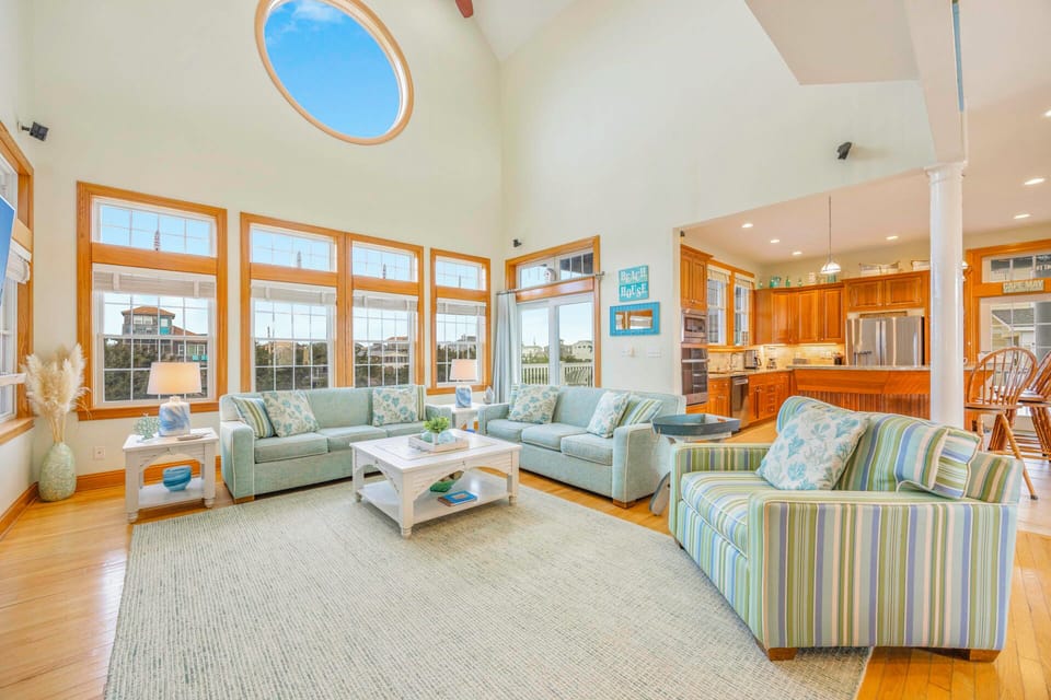 Relax in this bright, open living space where soaring ceilings and panoramic windows create an airy retreat for your coastal getaway.