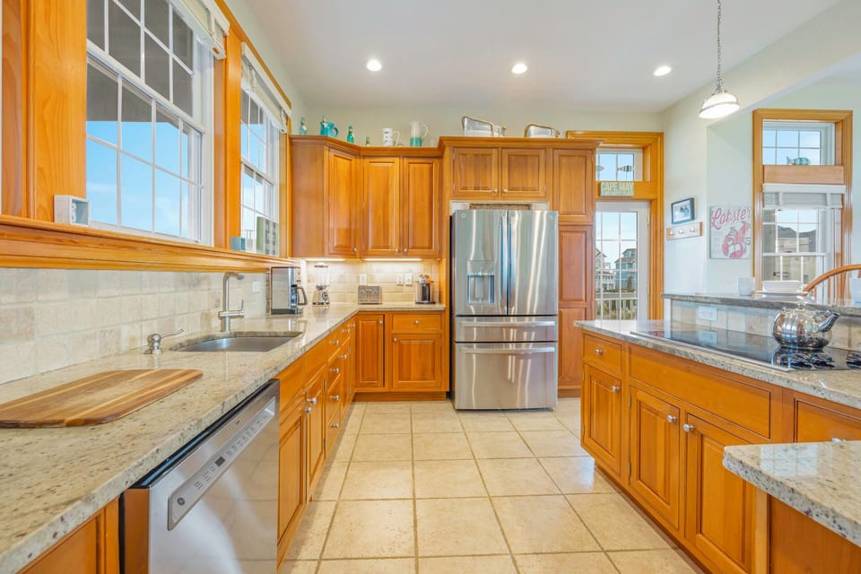 Your spacious kitchen welcomes culinary adventures with granite countertops, stainless steel appliances, and warm wood cabinetry bathed in natural light.