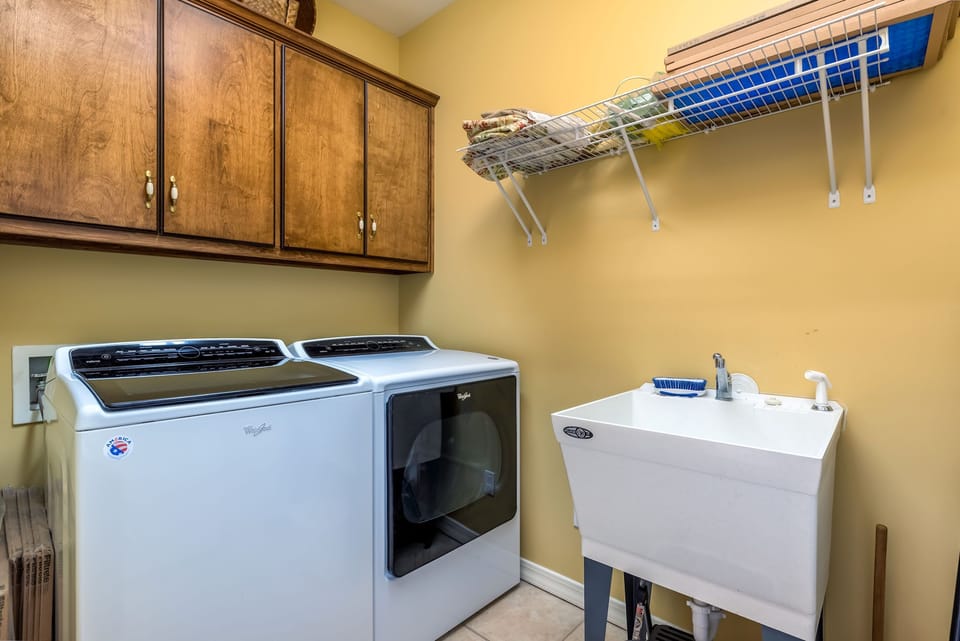Your laundry room with full-size washer and dryer, utility sink, and convenient storage space.