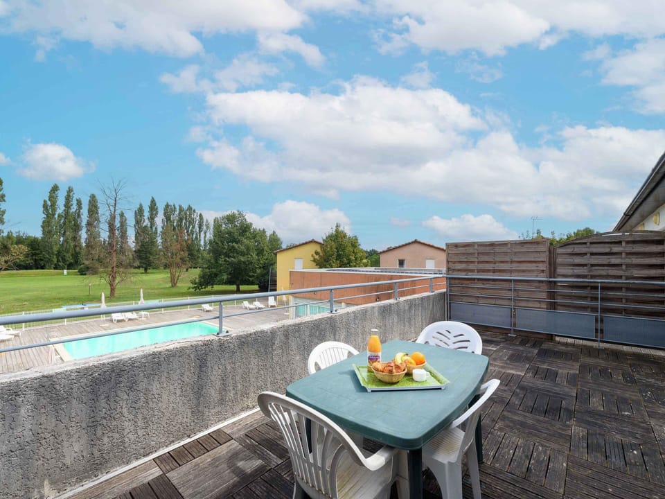 Enjoy breakfast on the spacious terrace, complete with a stunning view of the pool and surrounding greenery, perfect for relaxation.
