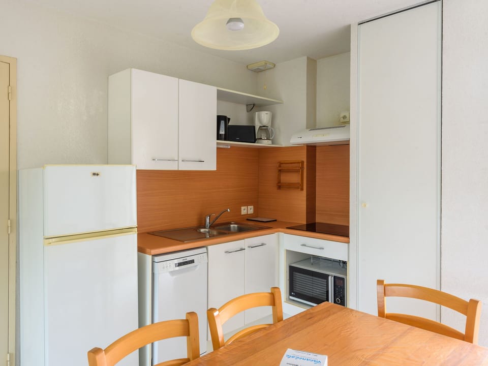 The well-equipped kitchen offers modern appliances and ample storage, making it easy to prepare meals for your group by the dining table.