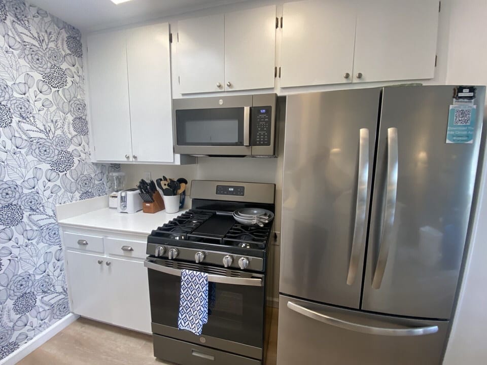 Your modern kitchen features stainless steel appliances and stylish floral wallpaper, creating the perfect space for preparing meals during your stay.