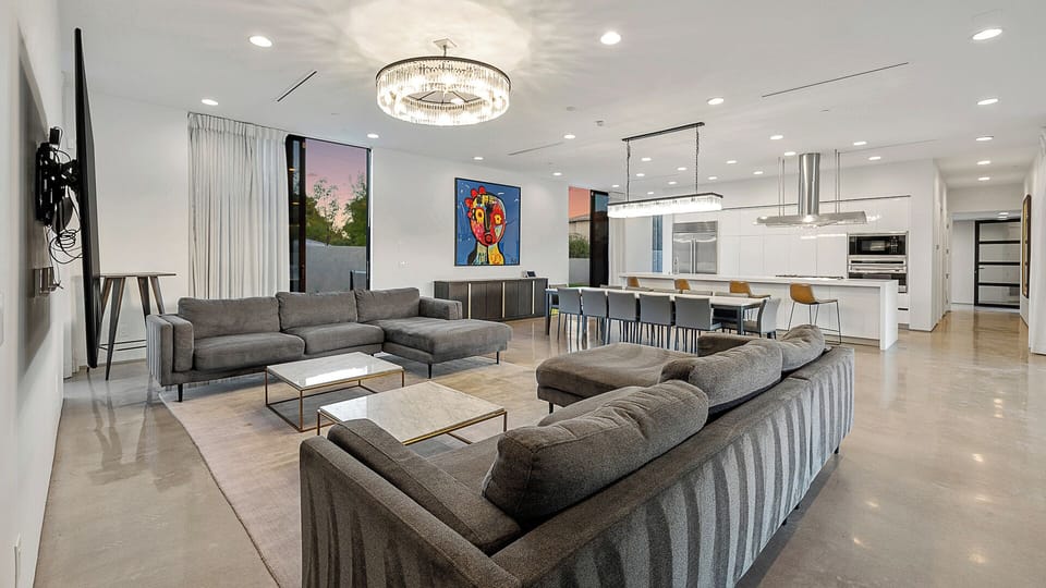 Grand open-concept living room with chef's kitchen & art