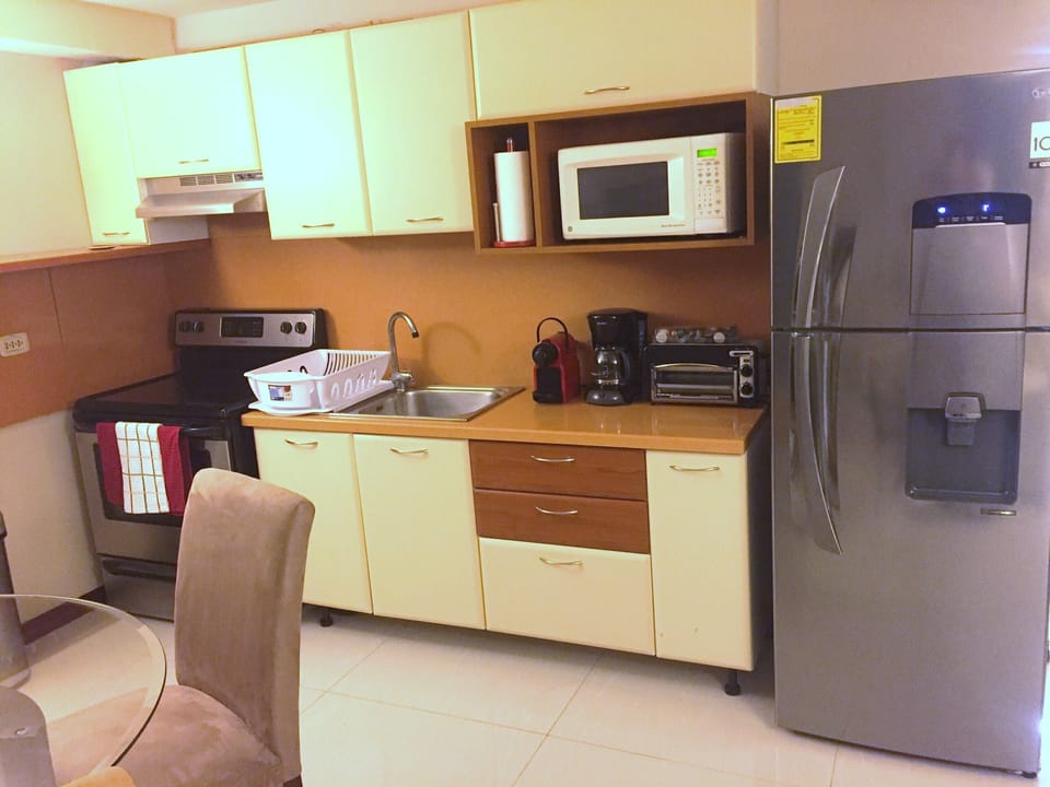 Kitchenette fully stocked, Appliances, pots and pans, silverware, ready to cook.