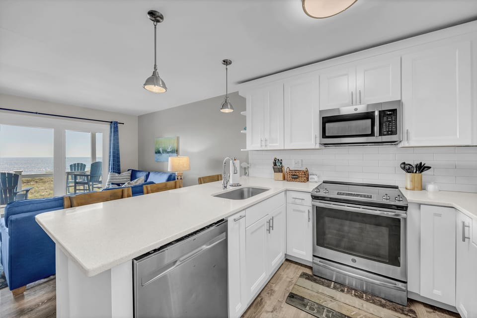 Bright, modern kitchen with everything you need to prepare your favorite meals, opening to a cozy living area where you can unwind with ocean views just beyond.
