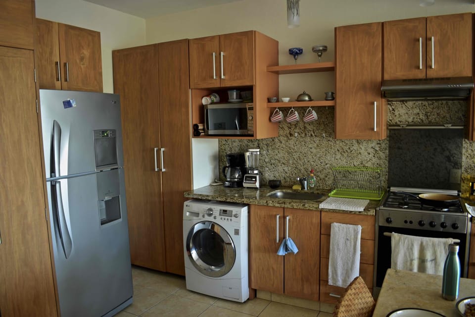 kitchen including laundry, gas stove, refrigerator, and water holder (not shown)