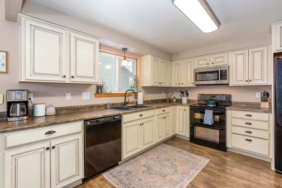 Large kitchen with black appliances. 