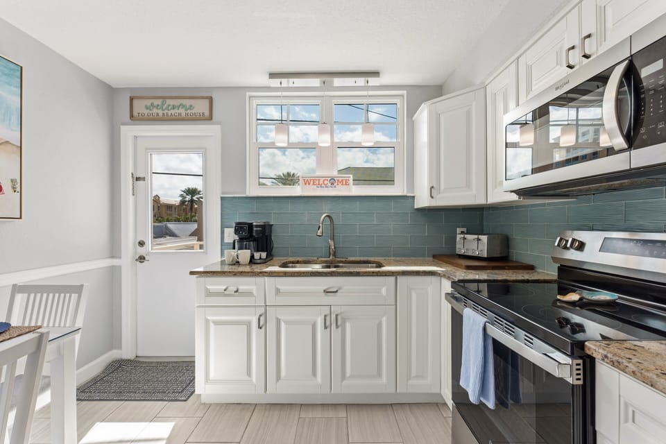 Our full kitchen Features stainless steel appliances including large fridge, stove, oven, blender and  microwave (Note: no dishwasher).