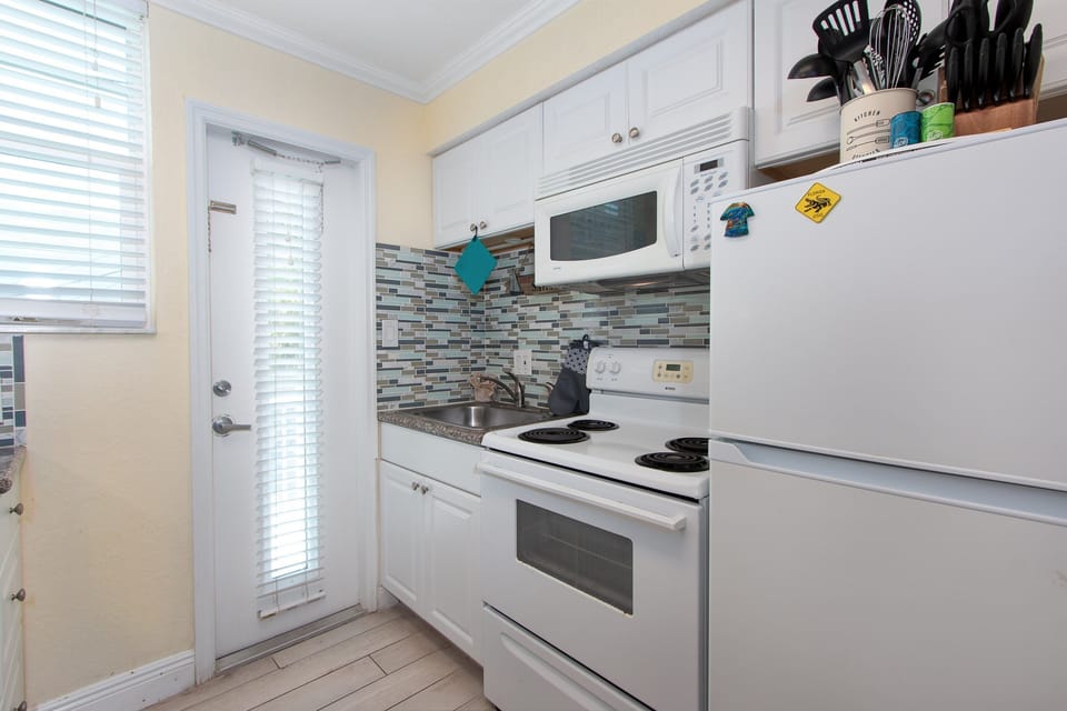 Fully equipped kitchen which includes fridge, stove, oven, microwave, toaster, and Keurig coffee maker.