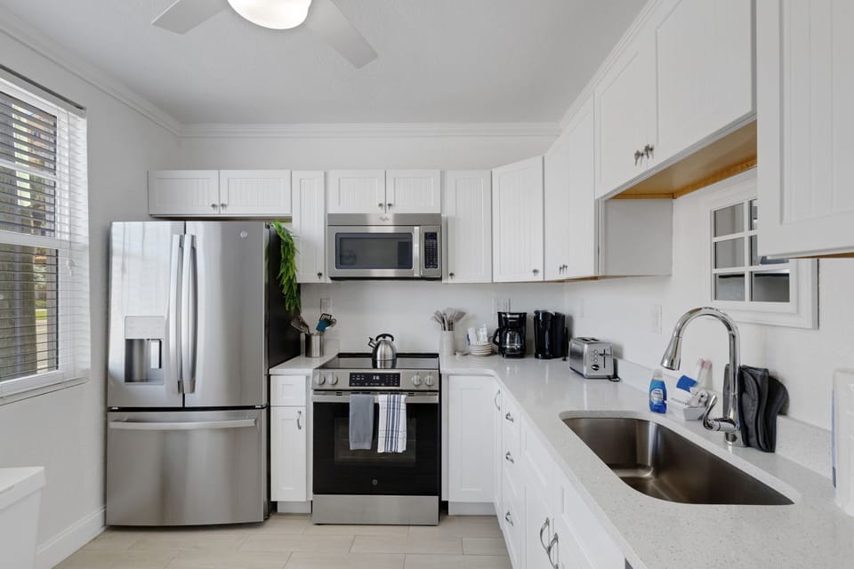 Kitchen: Features brand new stainless steel appliances including large fridge, stove, oven, microwave, and dishwasher.