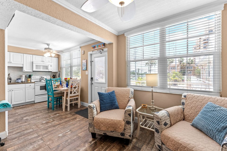 Fully equipped kitchen with fridge, oven, stove, microwave, and Keurig coffee maker, flowing into a cozy living and dining space.