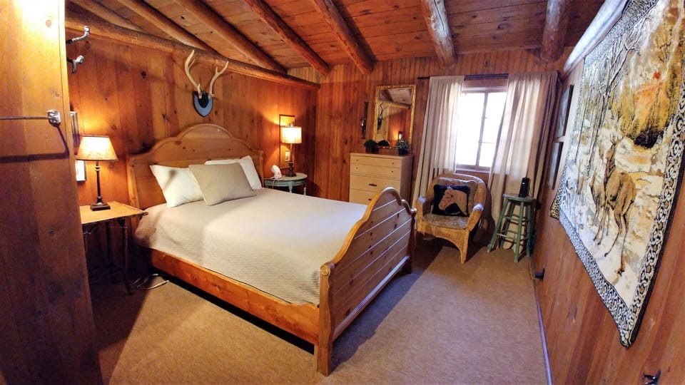 Drift off under rustic wood beams in your cozy retreat, where mountain charm meets inviting comfort. Crisp linens, warm lighting, and unique decor create your perfect alpine escape.