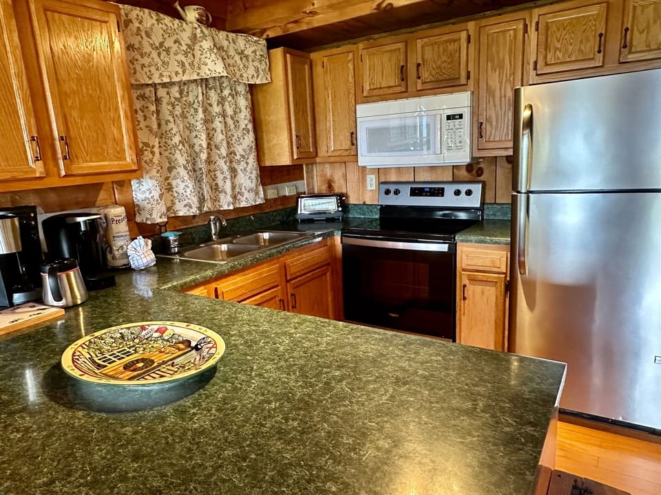 Cook with ease in a fully stocked kitchen featuring modern appliances and cabin-style charm.