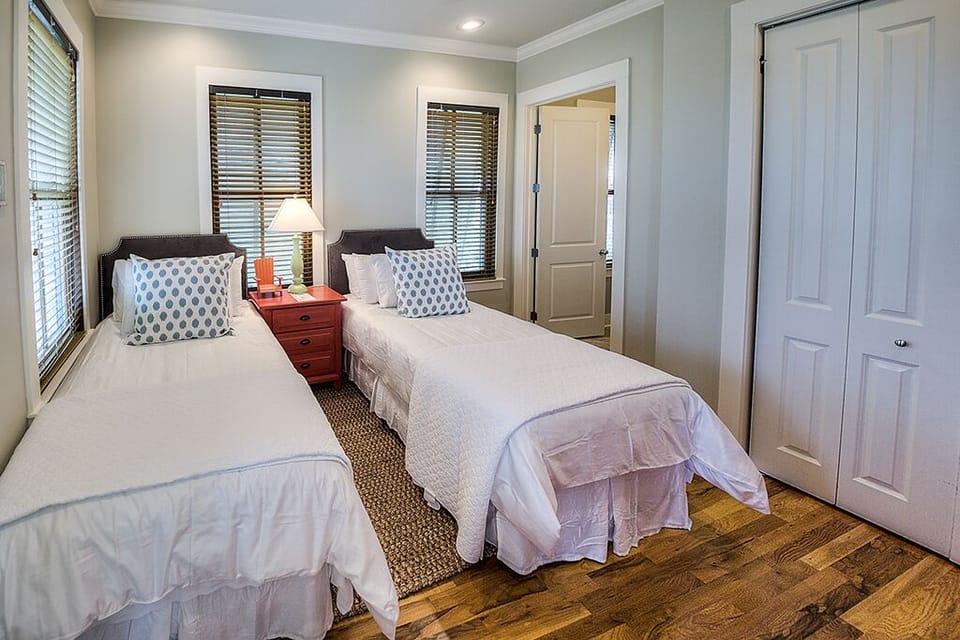 Bedroom with Two Beds, Closet, Nightstand, and Lamp.