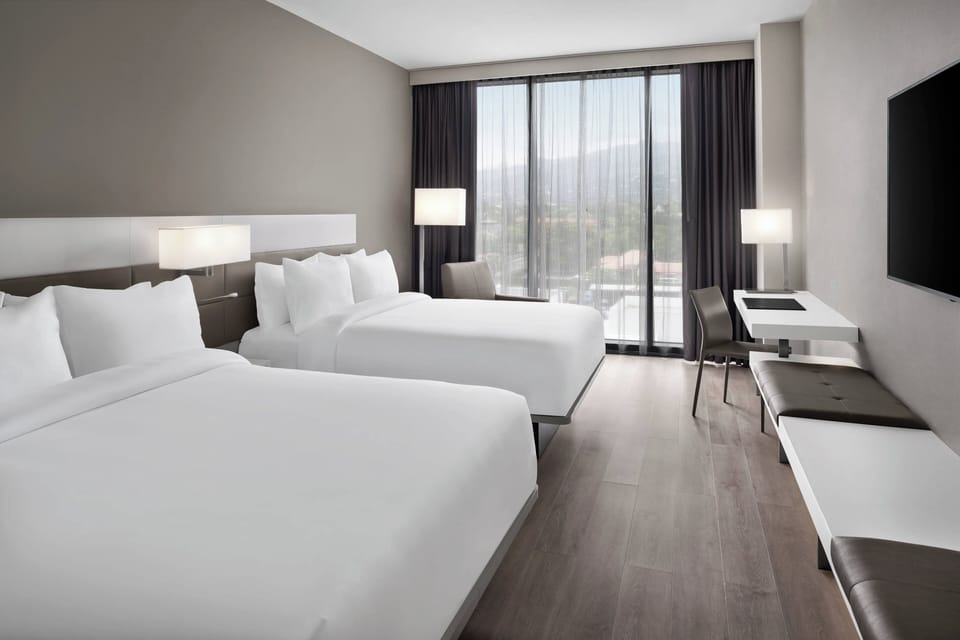 Room, 2 Queen Beds | Hypo-allergenic bedding, in-room safe, individually decorated, desk