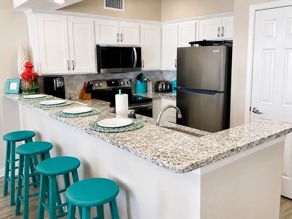 Fully equipped kitchen with granite breakfast bar and extra seating for four.