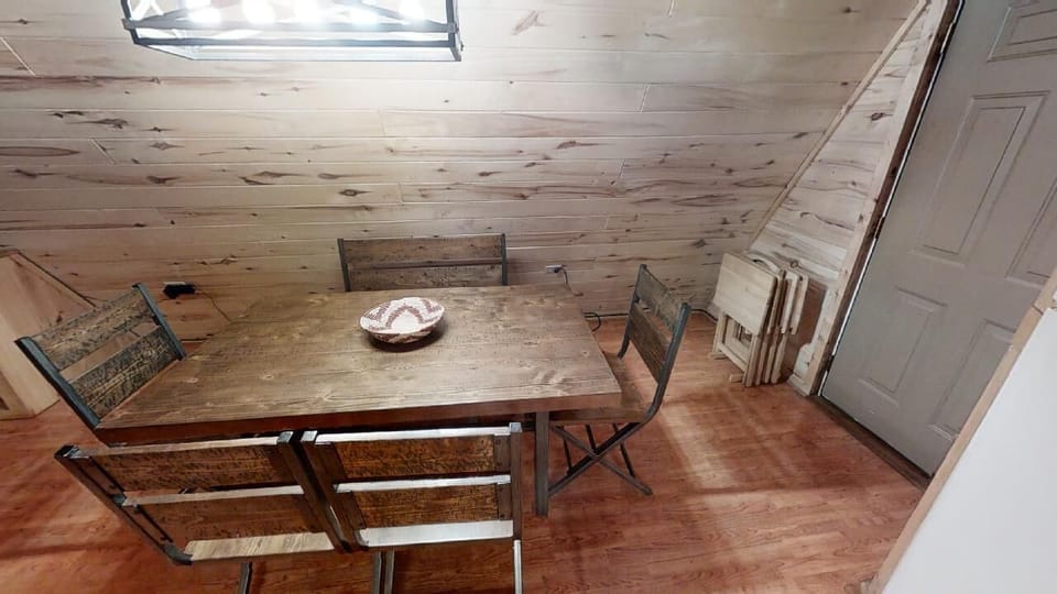 Gather around this charming rustic table beneath the skylight, where natural light filters through and wooden beams create a cozy, cabin-inspired atmosphere perfect for your morning coffee or evening meals.