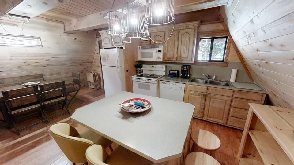 Step into your fully equipped kitchen, where warm wood and modern appliances invite you to prepare memorable meals during your mountain getaway.