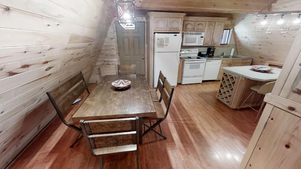 Cozy cabin-style kitchen with rustic wood walls, full appliances, and a charming dining nook where you can enjoy meals in your own mountain retreat.